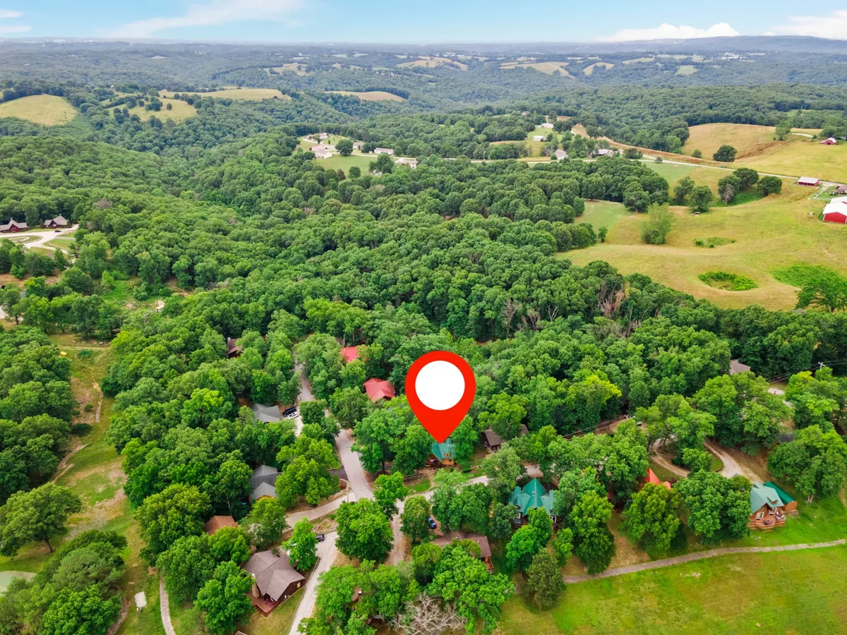 A sweeping landscape of lush green trees surrounds a scattering of residential homes and curving roads, evoking the feeling of a peaceful, nature-immersed community. The scene highlights tranquil walking opportunities and a sense of connection with nature.